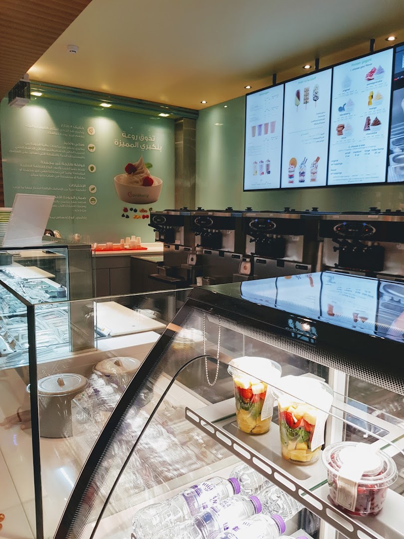 Interior view of a Pinkberry shop with frozen yogurt machines and a digital menu.