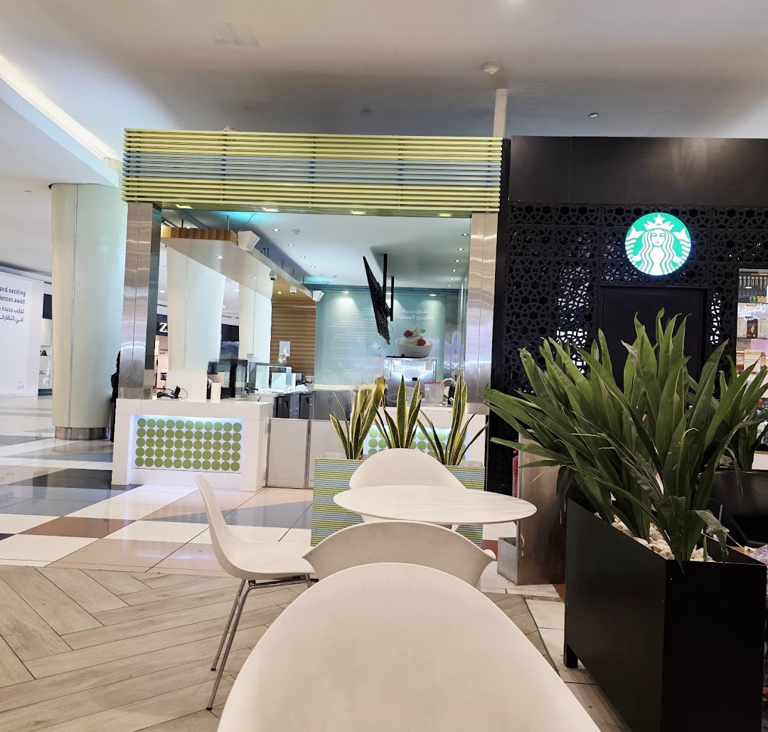 A Pinkberry frozen yogurt shop with seating area and a Starbucks sign visible.