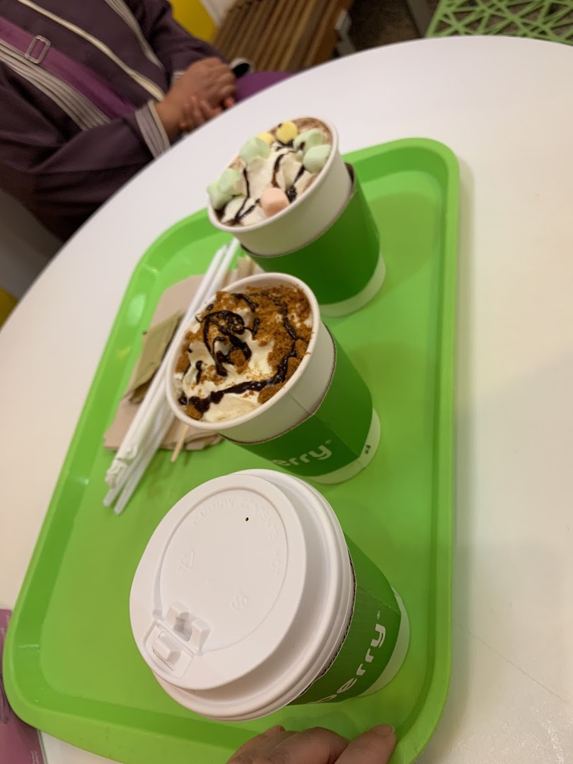 Two delicious frozen yogurt desserts topped with whipped cream and toppings on a green tray.
