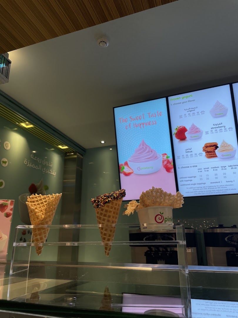 Pinkberry frozen yogurt shop display with cones and a digital menu board.