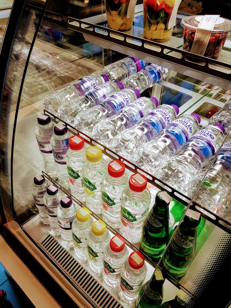 A display case filled with bottled water and some fruit cups.