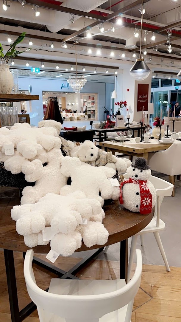 Cozy winter-themed display with plush snowmen and bears, set in a home decor store.