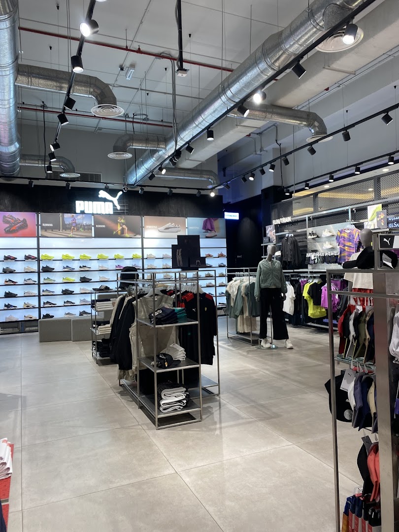 Interior view of a PUMA store showcasing athletic footwear and apparel on display.