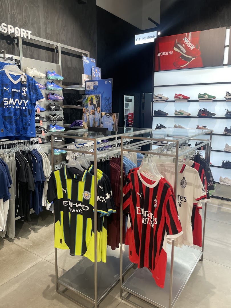 Interior view of a PUMA store showcasing football jerseys and athletic footwear.