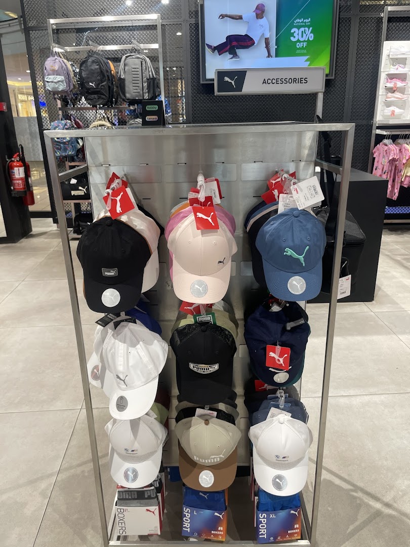 A display of various Puma caps and backpacks inside a retail store.
