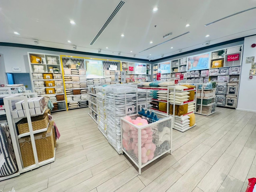 Interior view of a retail store displaying bedding, pillows, and home decor items on shelves and displays.