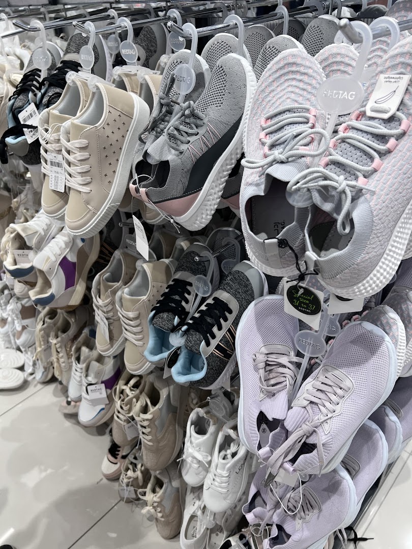 A display of various athletic and casual shoes for sale at Redtag.