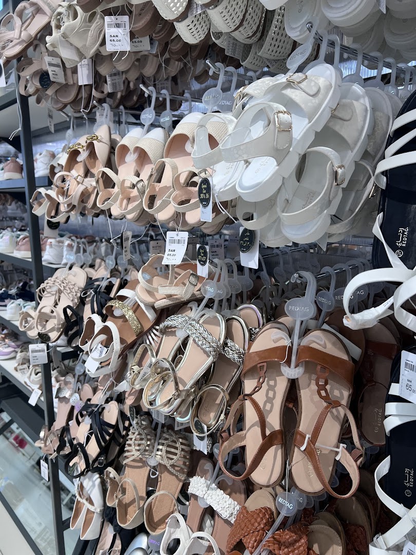 A wide selection of women's sandals displayed on racks in a retail store.