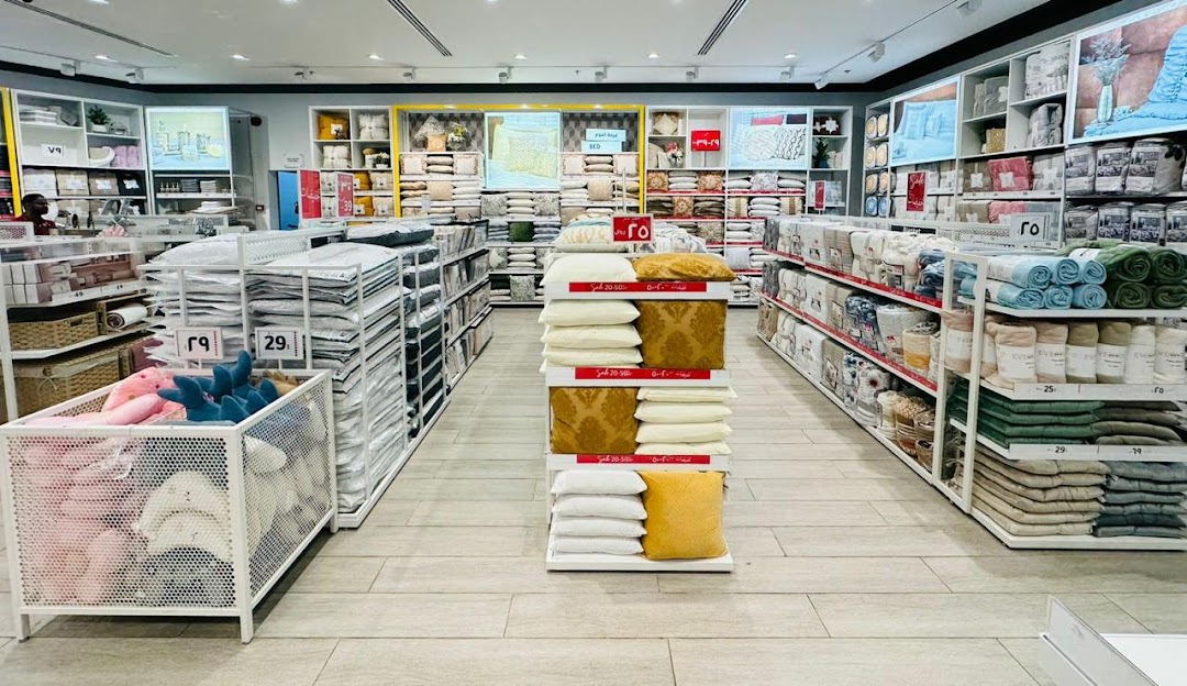 Interior view of a home goods store with bedding and pillows displayed on shelves and stands.