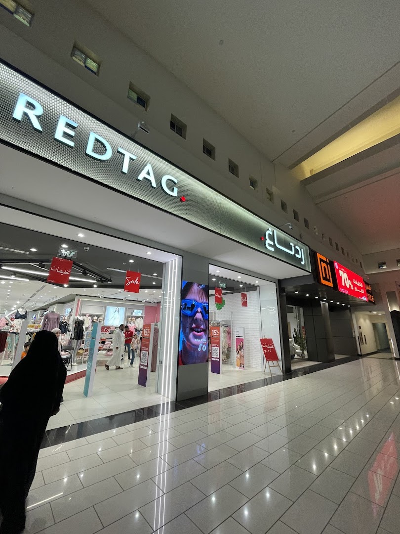 The Redtag store entrance with mannequins displaying clothing and sale signs.