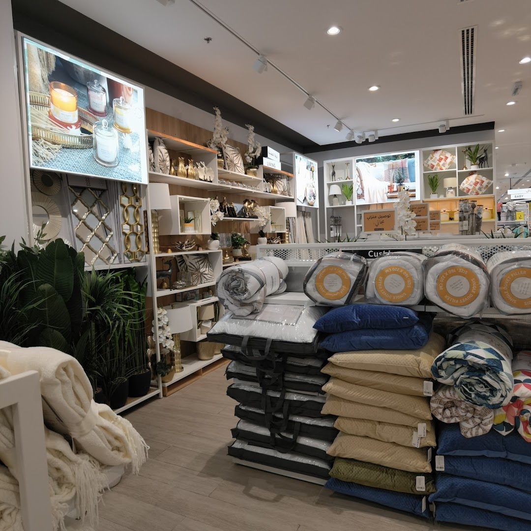 Interior view of a home goods store showcasing bedding, decor, and plants.