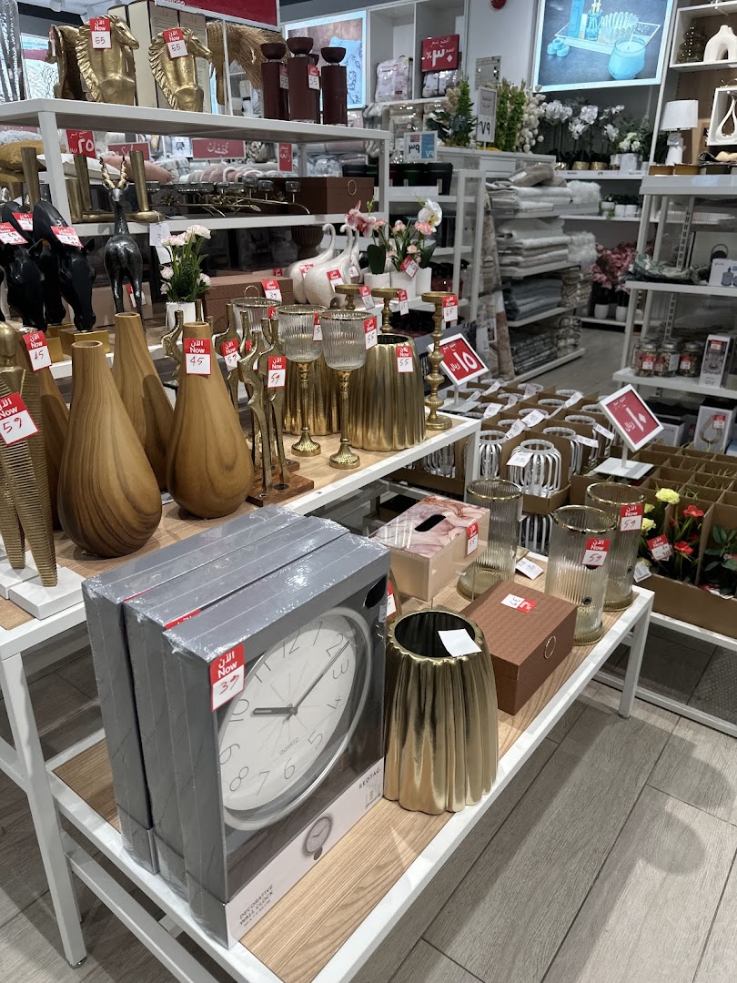 Interior view of a retail store displaying home decor items like clocks, vases, and decorative figures.