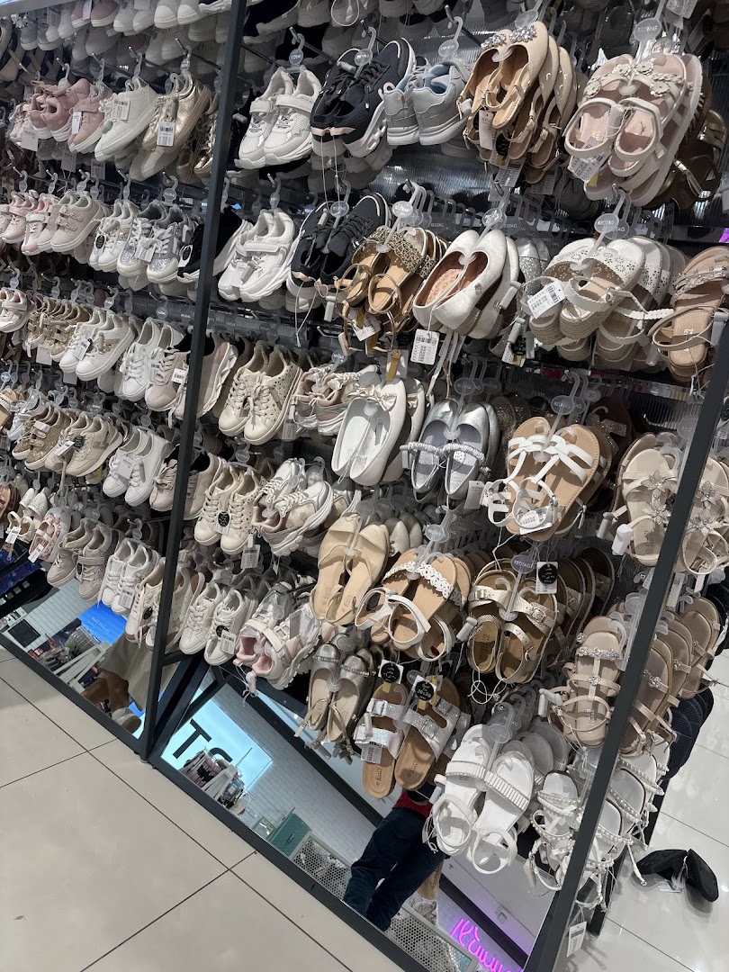 A wide selection of women's shoes, including sandals and sneakers, displayed on shelves.
