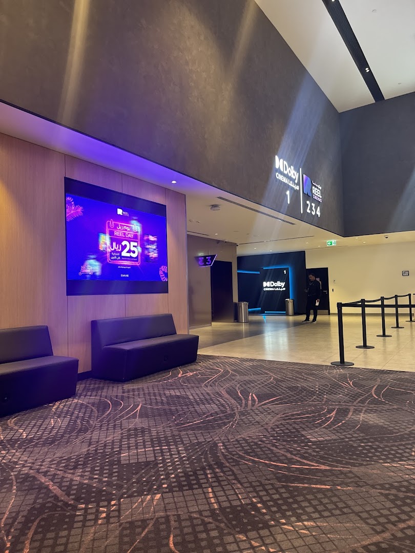 Interior view of a modern cinema lobby with seating and digital displays.