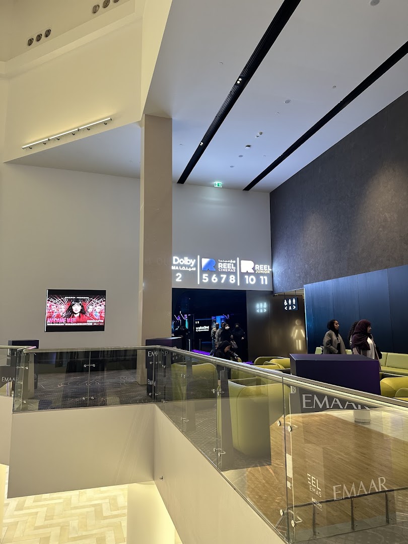 Interior view of a modern cinema lobby with seating areas and signage.