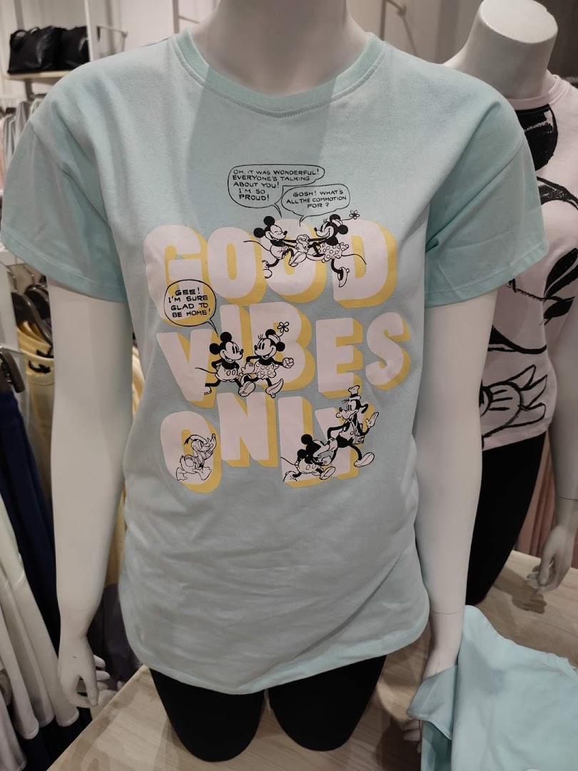 A light blue t-shirt with a cartoon print of Mickey Mouse and friends saying 'Good Vibes Only'.
