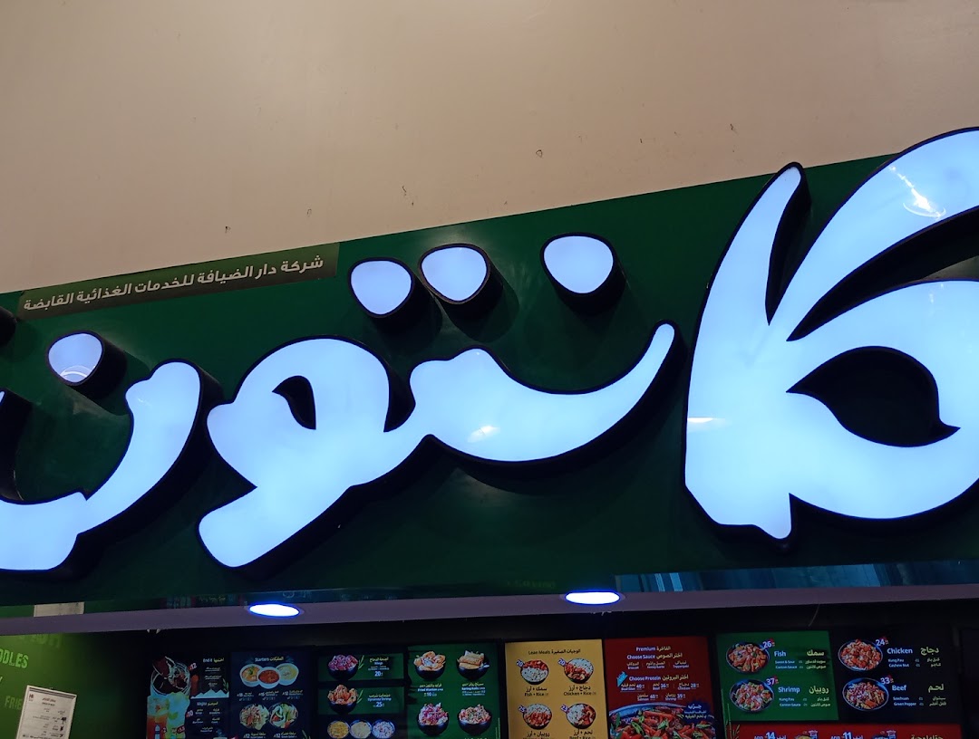 A brightly lit sign for 'Saj Express' with Arabic text and a menu below.