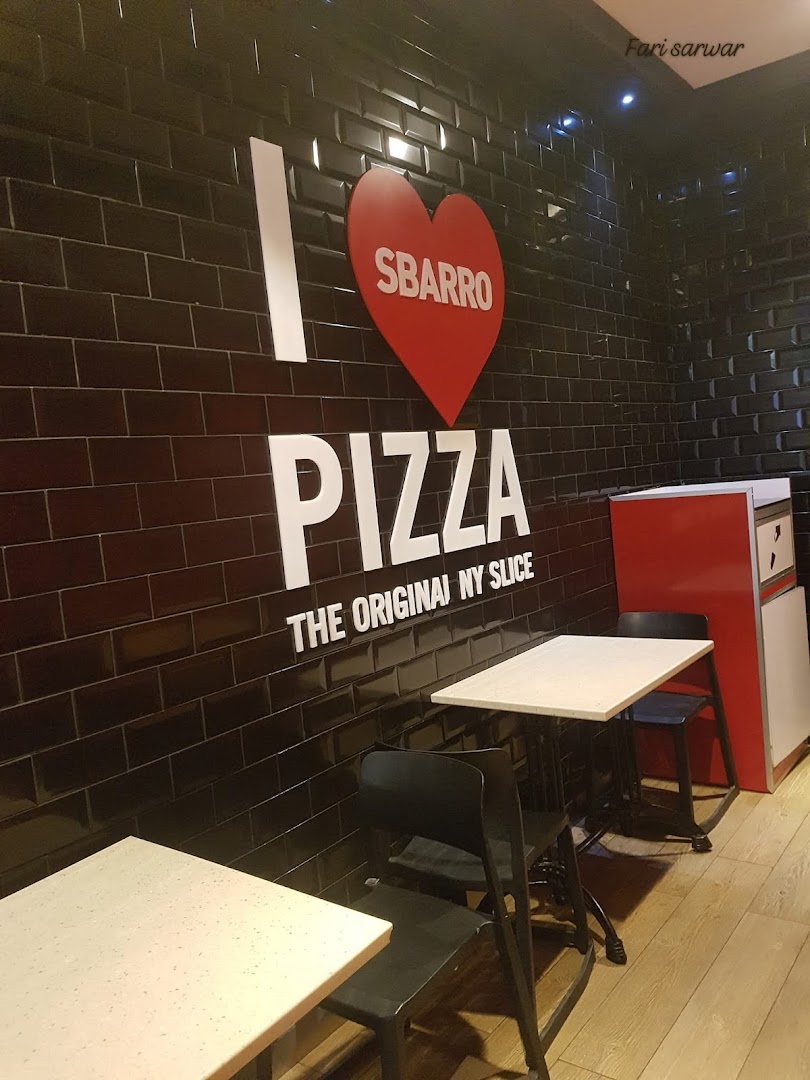 Interior shot of Sbarro with "I LOVE SBARRO PIZZA" wall art and seating.