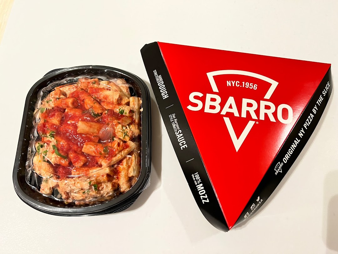 A container of pasta with tomato sauce and a Sbarro pizza slice box.
