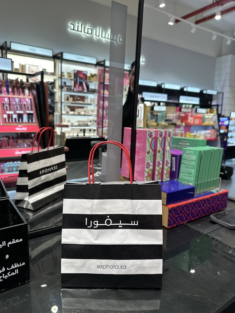 Sephora shopping bags and beauty products displayed inside a well-lit store.