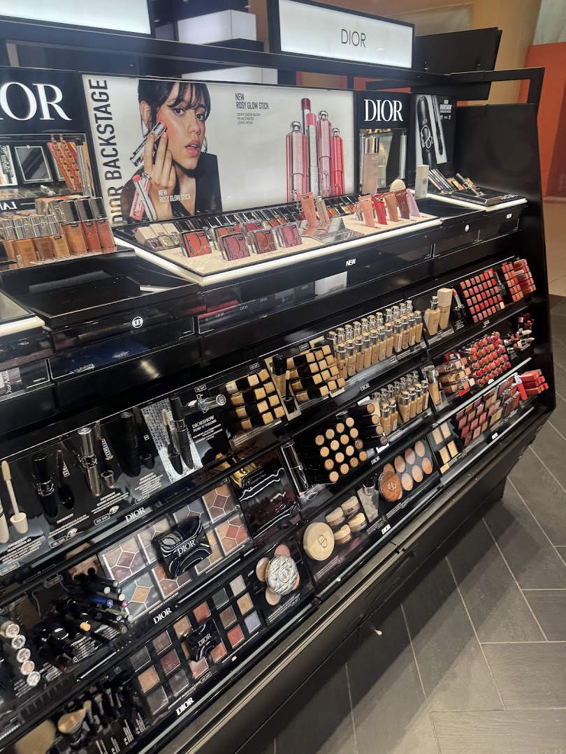 A display of Dior makeup products, including foundation, eyeshadow palettes, and lipsticks.