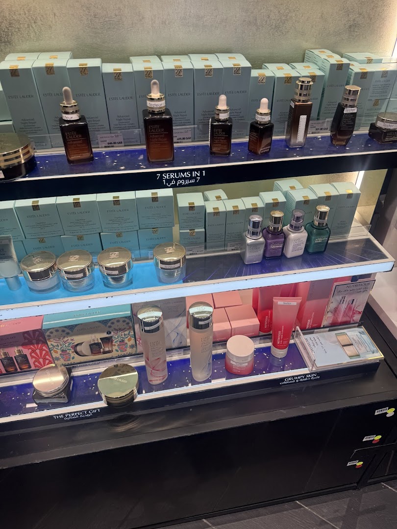 A display of Estee Lauder skincare products, including serums and creams, on shelves.