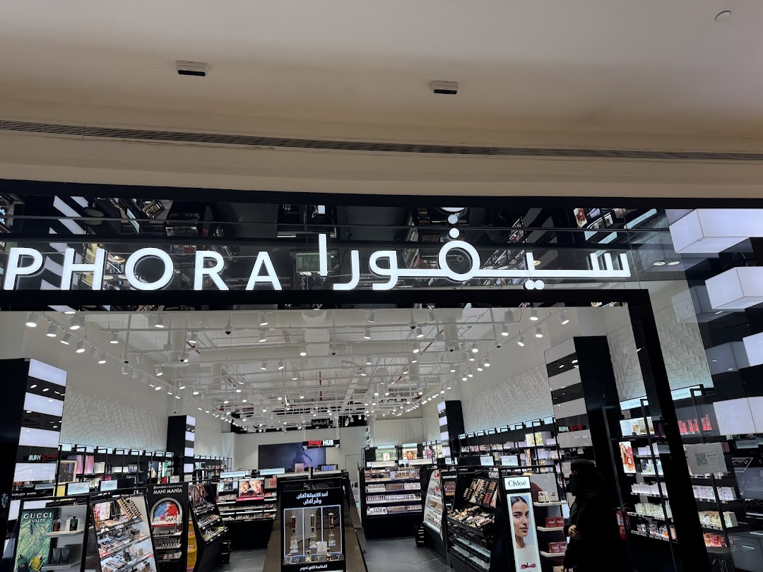 The entrance of a Sephora store with illuminated signage and displays of beauty products.