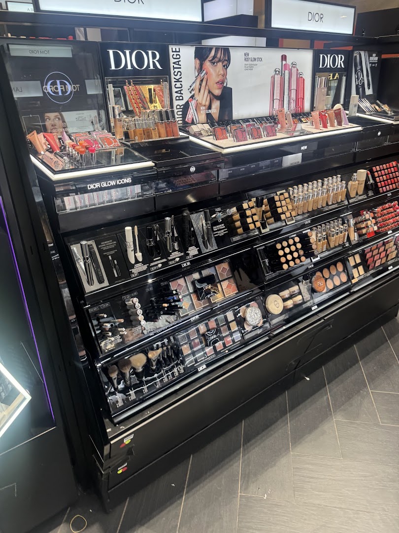 A display of Dior makeup products including lipsticks, foundations, eyeshadows, and brushes.