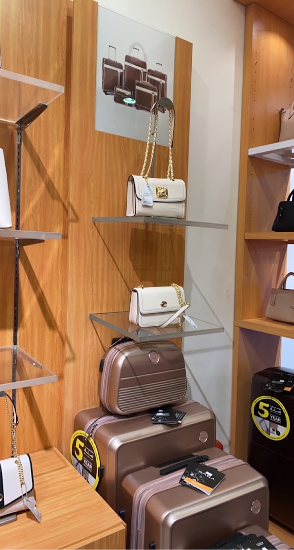 A display of stylish handbags and luggage in a retail store.