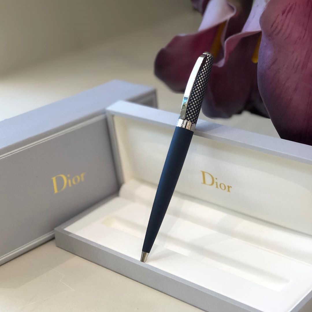 A luxurious Dior pen presented in its elegant packaging with a floral accent.