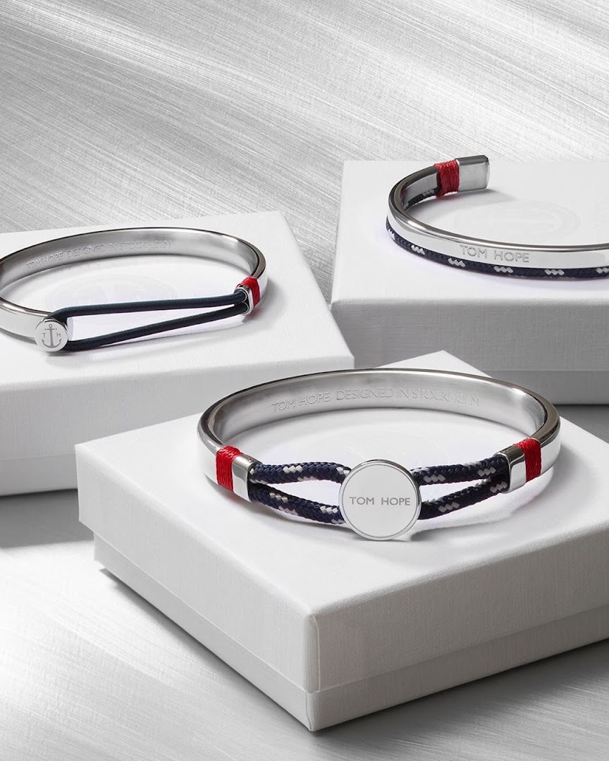 Three stylish bracelets with nautical rope details displayed on white boxes.