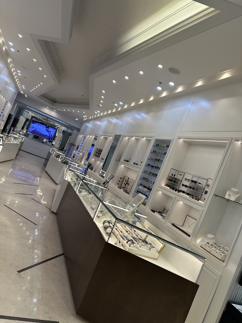 Interior view of a modern jewelry and eyewear store with display cases and shelves.