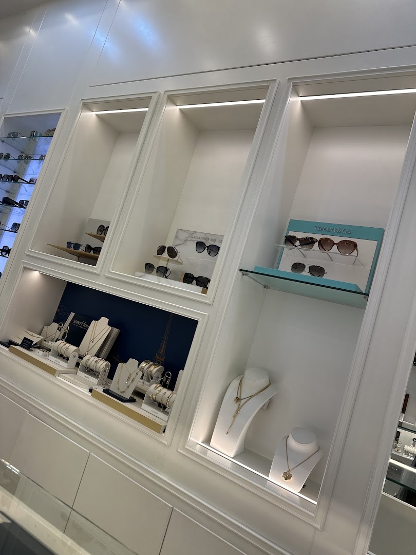 A well-lit display of jewelry and sunglasses in a modern retail store.