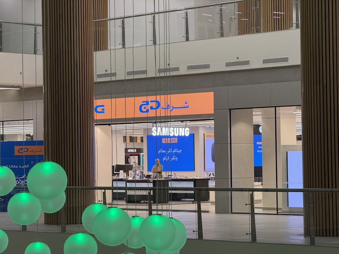 Sharaf DG electronics store featuring Samsung and Hitachi displays, with staff visible inside.