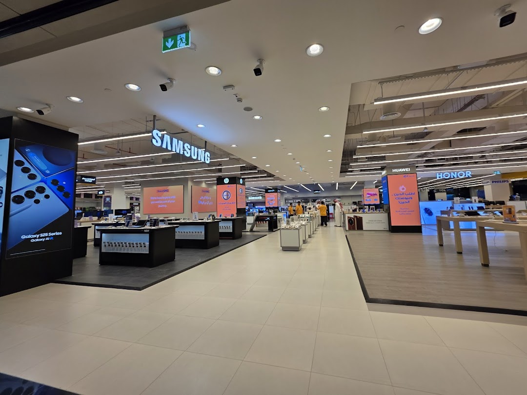 Interior view of a large electronics store with displays for Samsung, Huawei, and Honor products.