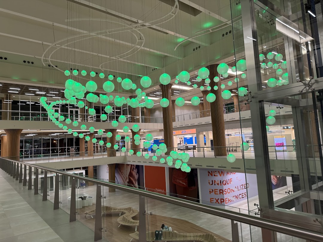 Interior view of a modern shopping mall with a large decorative light installation.