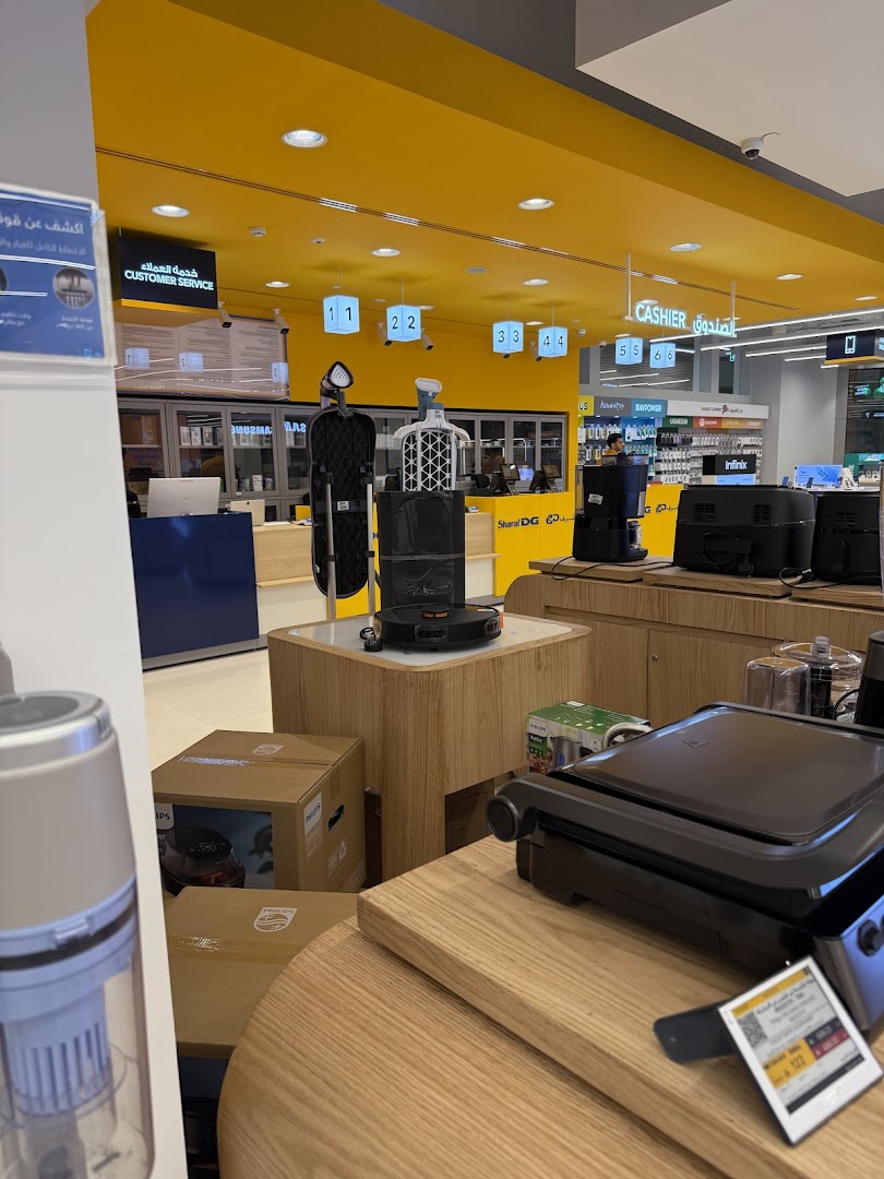 Interior view of a Sharaf DG electronics store showcasing various appliances and displays.