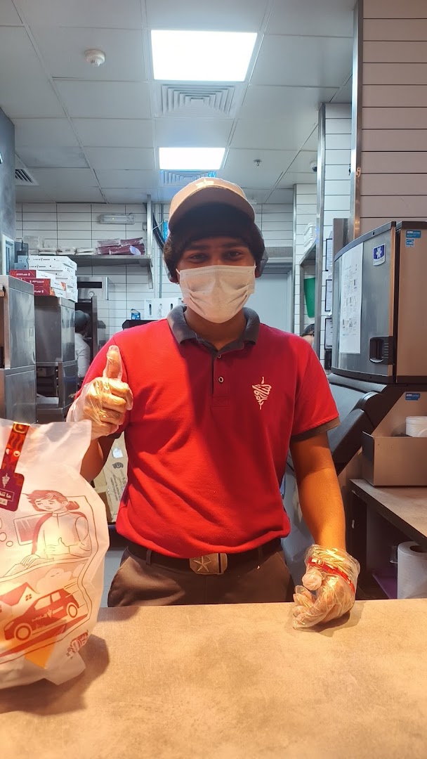 A Shawarmer employee wearing a mask and gloves gives a thumbs up.