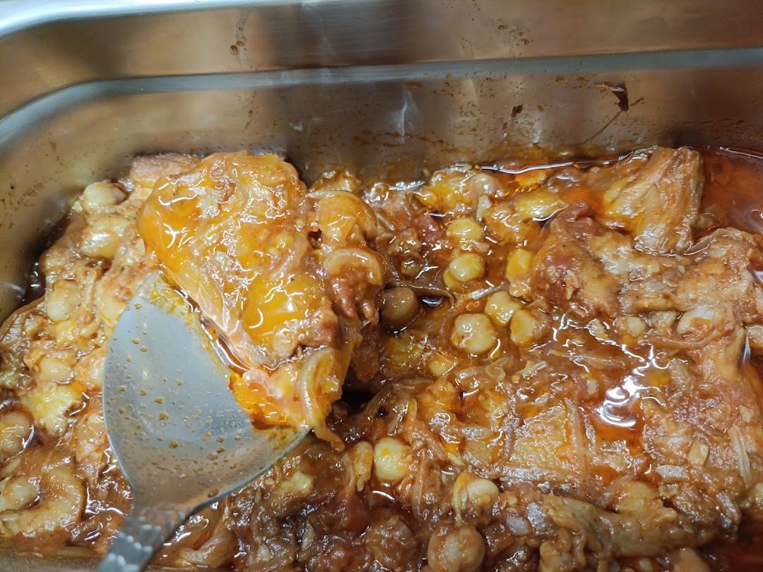 A close-up of a hearty stew with tender meat and chickpeas in a rich sauce.