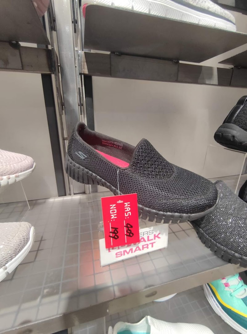 A close-up of Skechers Go Walk shoes on display with a red sale tag.