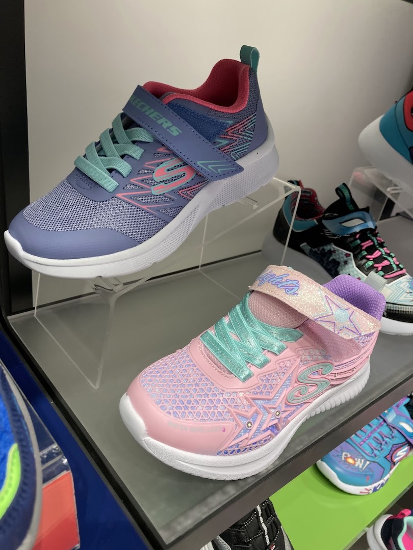 Close-up of colorful Skechers children's shoes displayed on shelves.