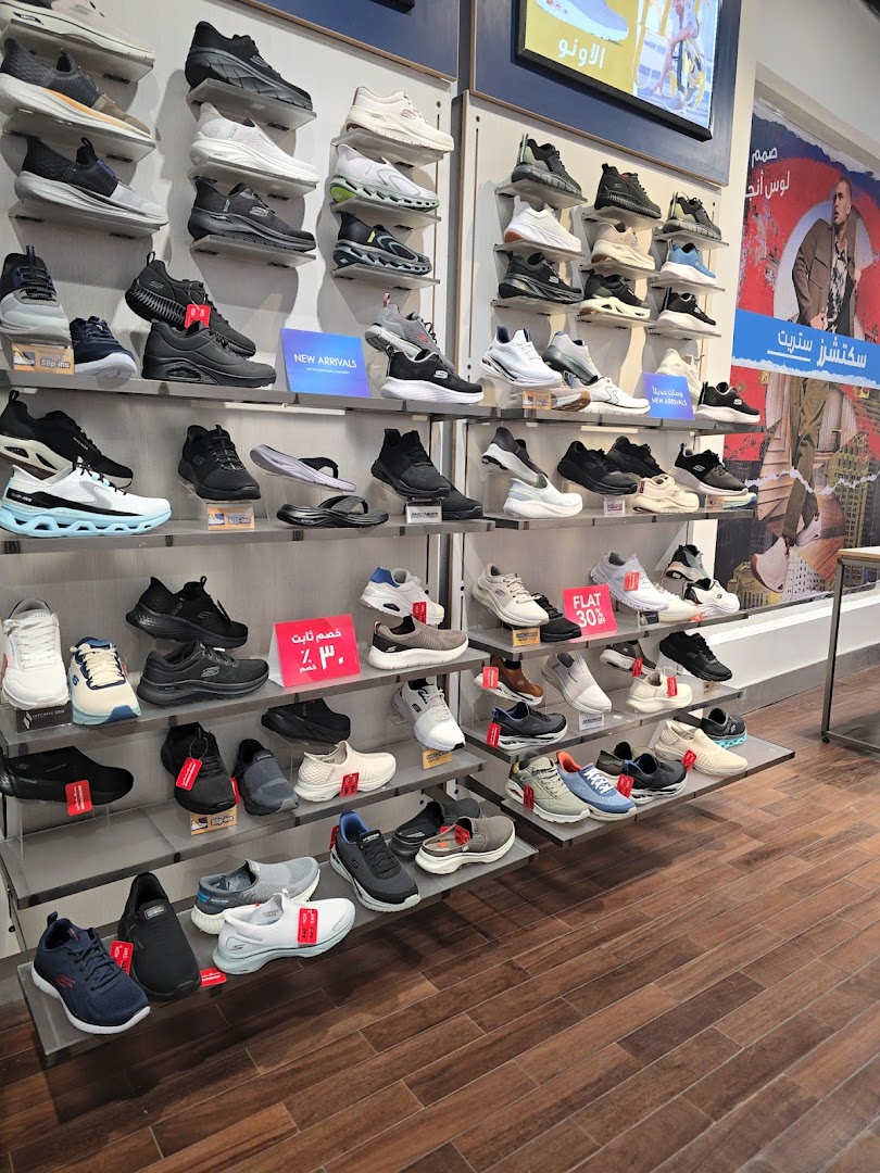 A wide selection of Skechers shoes displayed on shelves in a retail store.