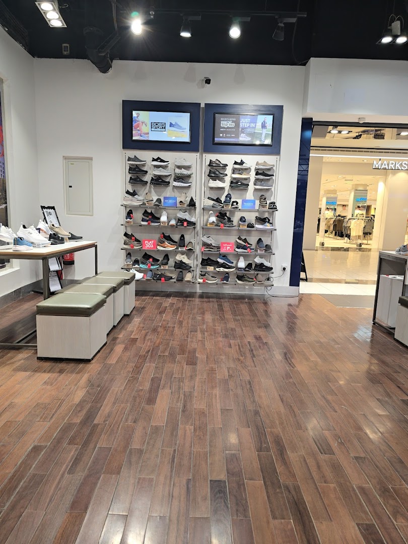 Interior view of a Skechers store showcasing various shoe displays and seating.