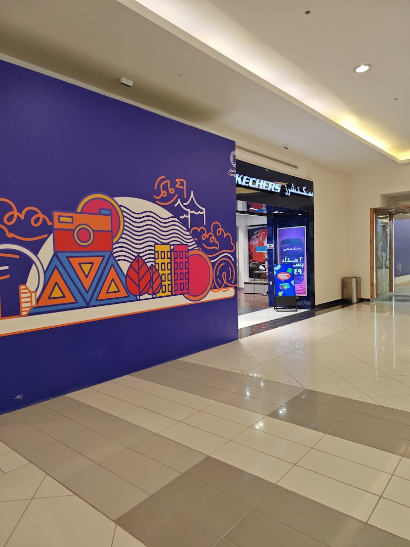 The entrance to a Skechers store in a mall, featuring a colorful mural on the left.