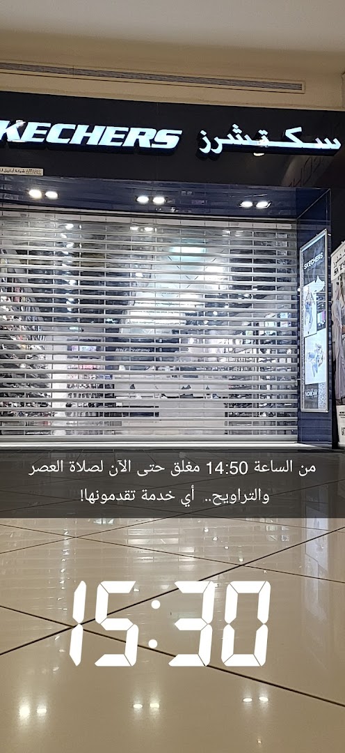 The Skechers store is closed with its metal security gate down, showing a time of 15:30.