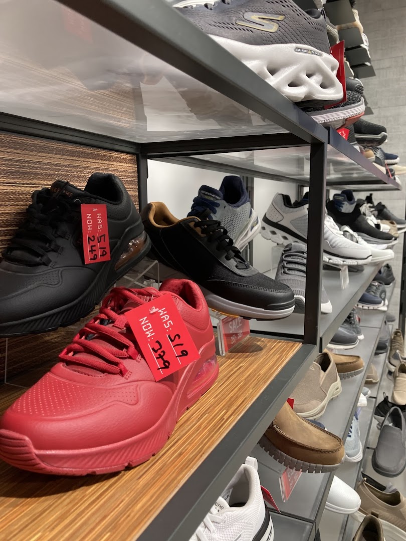 Shelves filled with various Skechers shoes, including athletic and casual styles, with some on sale.
