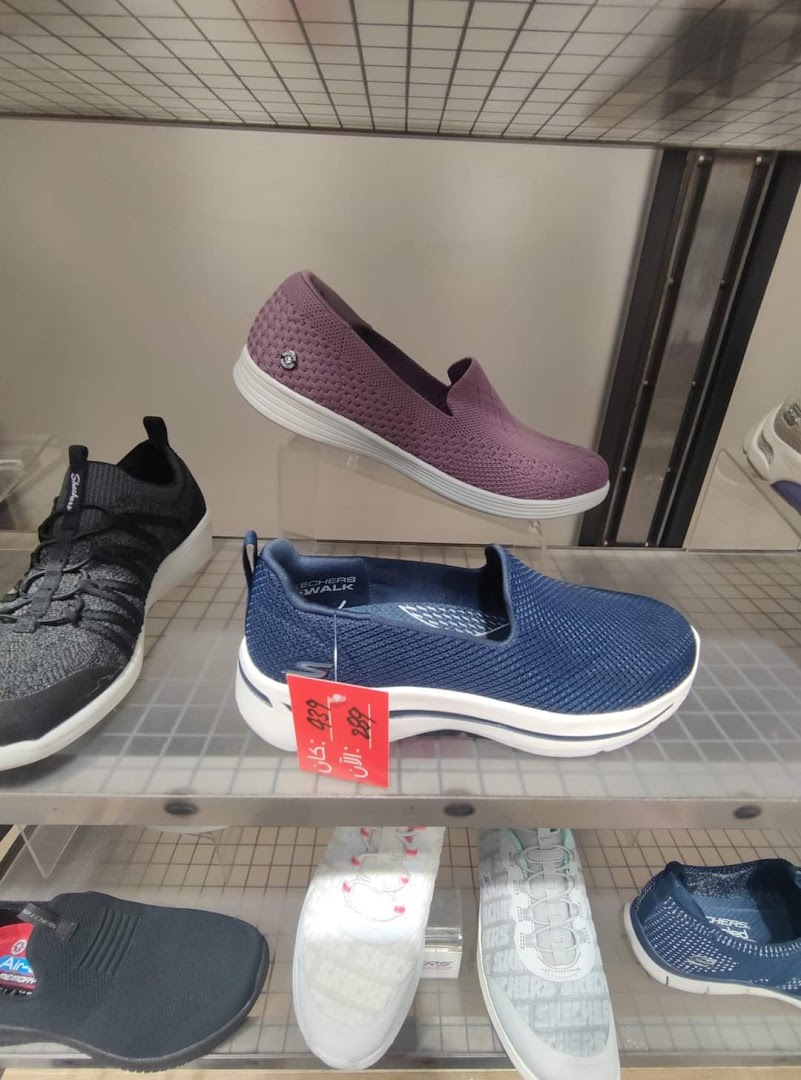 A display of Skechers shoes, featuring purple and blue slip-on styles with price tags.
