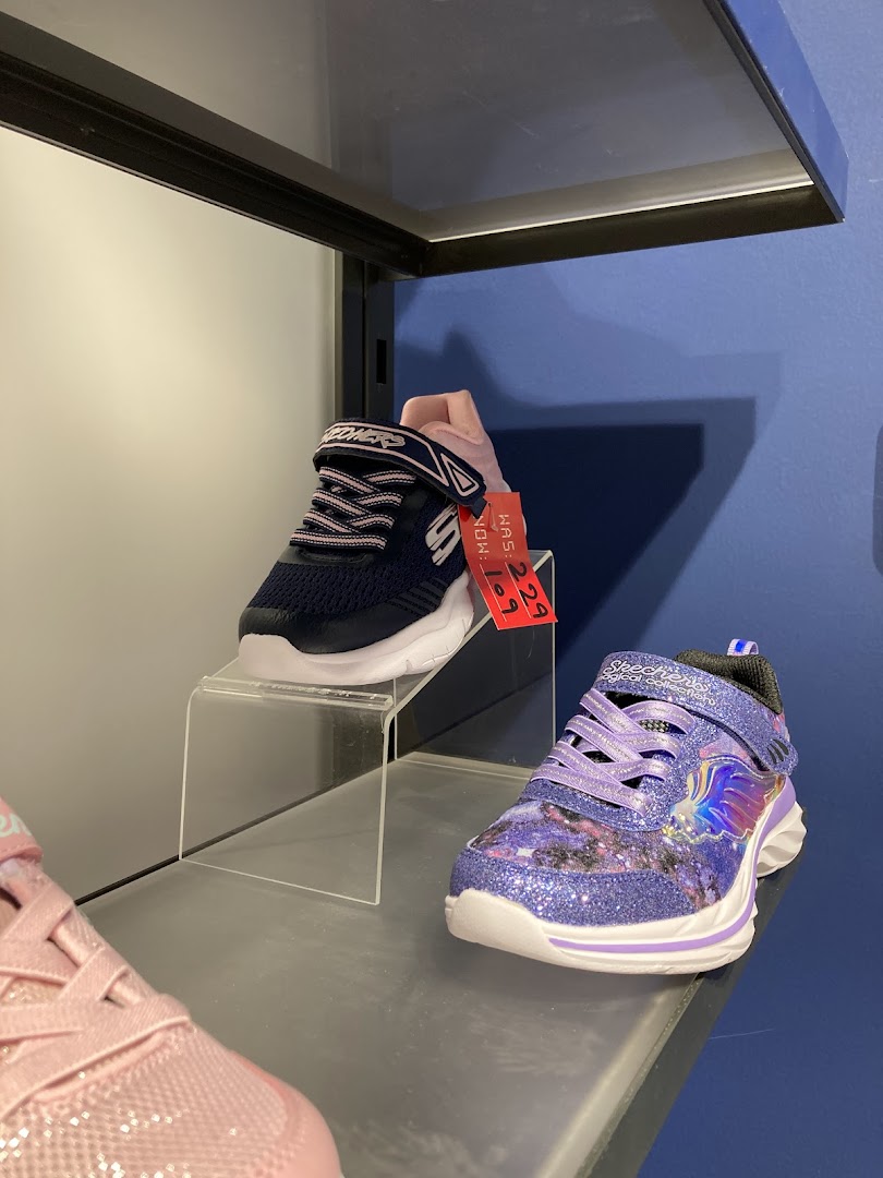 Close-up of children's Skechers shoes, one navy and one purple with glitter.