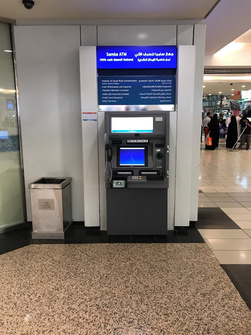 A Samba ATM machine with a list of services displayed on a blue illuminated sign.