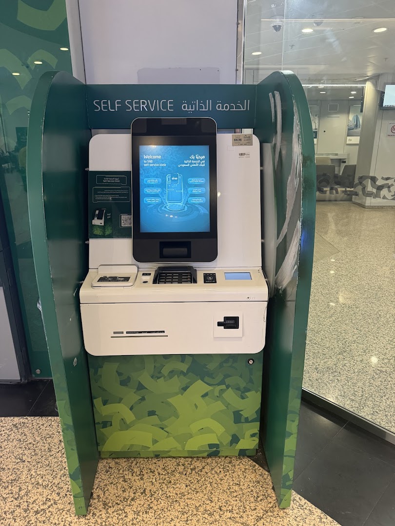 A self-service kiosk for SNB AlAhli bank with a touch screen and card reader.